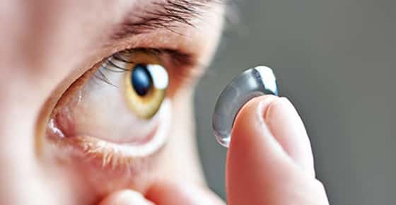 Image of someone putting in a contact lens.