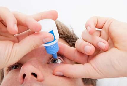 person using eye drops