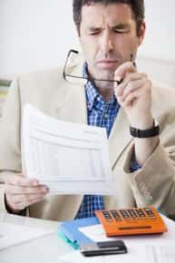 man taking off glasses to read